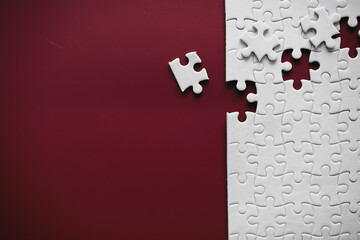 Clean puzzle elements on the red background. Empty puzzle piece on the table. Teamwork concept.