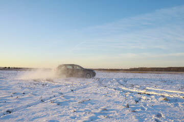 Car in the field in winter. Off-road winter snow drifts. Extreme sport, entertainment.