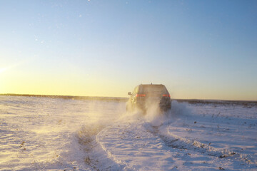 Car in the field in winter. Off-road winter snow drifts. Extreme sport, entertainment.