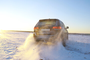 Car in the field in winter. Off-road winter snow drifts. Extreme sport, entertainment.