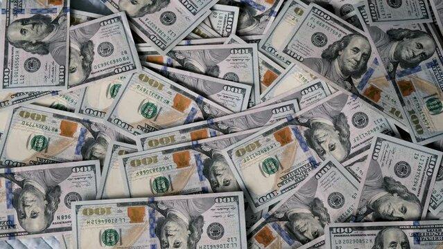 US hundred dollar bills are scattered in a chaotic manner. Close-up.