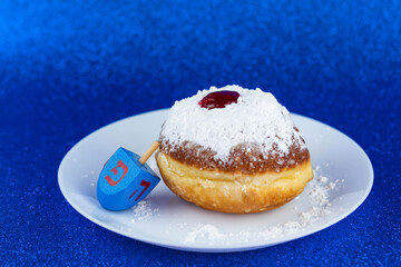 Jewish holiday Hanukkah concept. Menorah - traditional candelabrum or hanukkiah, donut sufganiyot and wooden dreidel - spinning top