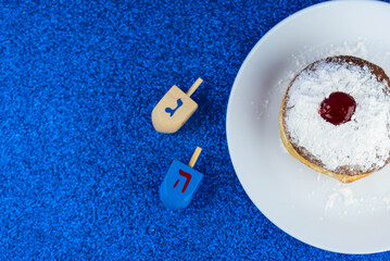 Jewish holiday Hanukkah concept. Menorah - traditional candelabrum or hanukkiah, donut sufganiyot and wooden dreidel - spinning top