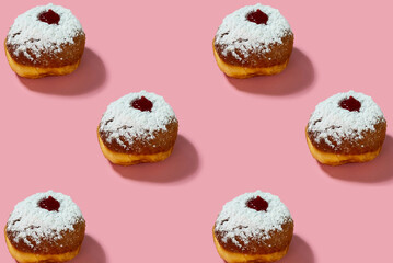 Jewish holiday Hanukkah concept. Pattern with donut sufganiyot on a pink background.