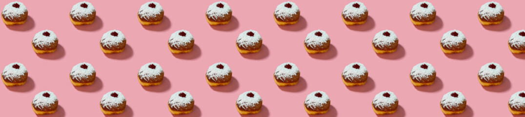 Jewish holiday Hanukkah concept. Pattern with donut sufganiyot on a pink background.