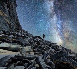 Wanderer bei Nacht auf einem Bergpass mit schönem Sternenhimmel im Hintergrund