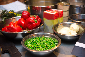 A set of raw food ingredients before making dinner. Fresh green peas, ripe red bell peppers, onions.