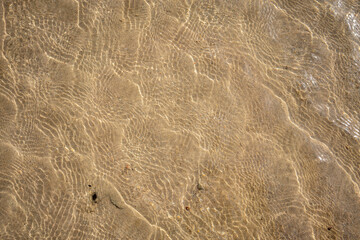 sandy bottom of the red sea at low tide with ripples from the waves