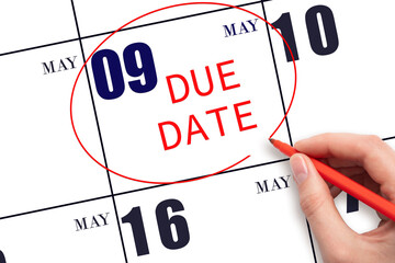 Hand writing text DUE DATE on calendar date May 9 and circling it. Payment due date