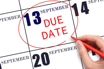 Hand writing text DUE DATE on calendar date September 13 and circling it. Payment due date