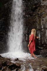 Woman posing in front of a waterfall