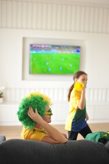 mãe e filha assistindo jogo do brasil copa do mundo pela tv em casa cores lindas 