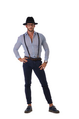 Handsome man in shirt, suspenders, hat and glasses in studio