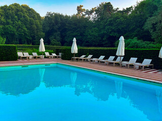 Outdoor swimming pool in luxury hotel on sunny summer day. Time for relax