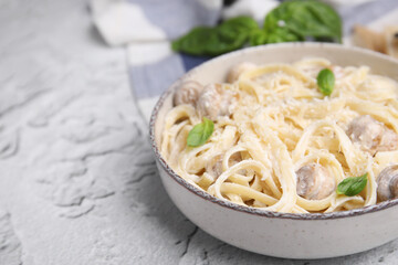 Delicious pasta with mushrooms and cheese on light grey textured background, closeup