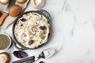 Delicious pasta with mushrooms served on white table, flat lay. Space for text