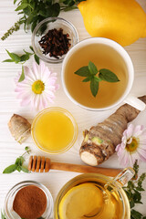 Flat lay composition with cup of delicious tea, honey and ginger on white wooden table