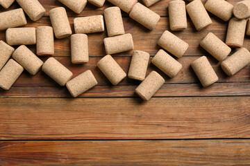 Many corks of wine bottles on wooden table, flat lay. Space for text