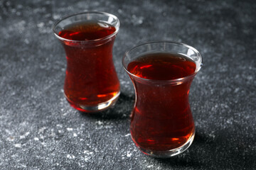 Glasses of traditional Turkish tea on grey textured table, closeup