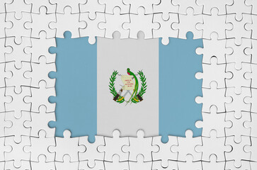 Guatemala flag in frame of white puzzle pieces with missing central parts