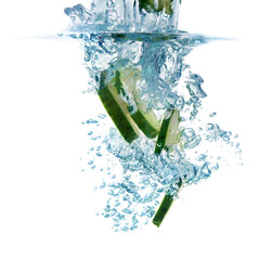 Slices of fresh cucumber falling into water on white background, closeup