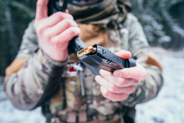 Soldier in uniform loads his personal weapon