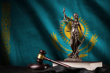Kazakhstan flag with statue of lady justice, constitution and judge hammer on black drapery....