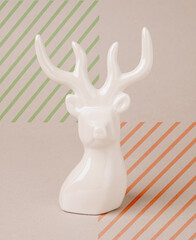 Reindeer head against the cardboard background with diagonal colorful lines. Minimal, modern Christmas concept.