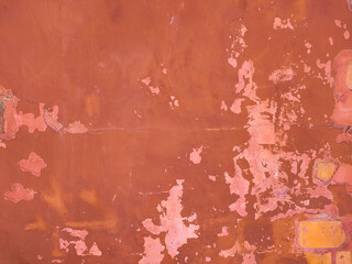 detail of the texture of a brick wall with weathered red paint