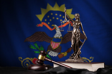 North Dakota US state flag with statue of lady justice, constitution and judge hammer on black...