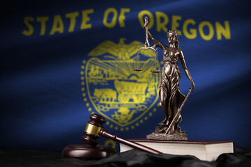 Oregon US state flag with statue of lady justice, constitution and judge hammer on black drapery....