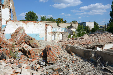 Collapsed industrial multistorey building in daytime. Disaster scene full of debris, broken bricks...