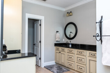 A double bathroom vanity with black granite counter tops and cream custom cabinets