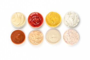 Different types of sauces in bowls on a white background.