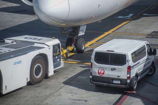 air plane parked near gate on platform with push car -Los Angeles, United States - February 23 2020