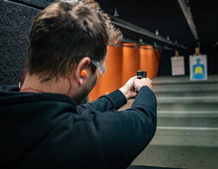 Fototapeta premium person with gun training in a shooting range in Michigan
