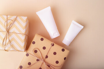 Top view of blank cosmetics tube with gift boxes near it.Festive concept.