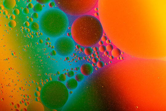 Macro photography of the oil drops on the water surface.Cosmic circles looks like molecule structure.Backdrop with copy space,good as template.