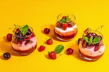 Delicious Italian dessert panna cotta with sweet cherry sauce, strawberry jam, fresh berries, mint