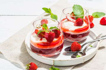 Italian dessert panna cotta in glass with strawberries. Healthy sweet food, hard light, dark shadow