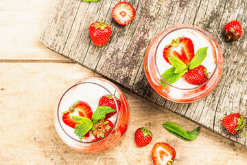 Italian dessert panna cotta in glass with strawberries. Healthy sweet food, hard light, dark shadow