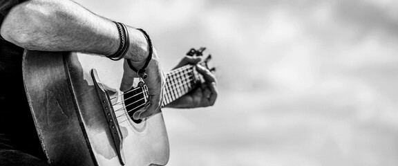 Acoustic guitars playing. Music concept. Black and white. Male musician playing guitar, music instrument. Man's hands playing acoustic guitar, close up - obrazy, fototapety, plakaty