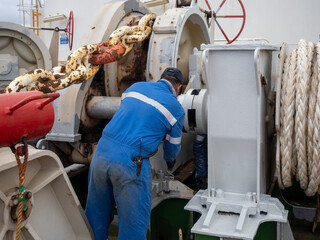 maintenance of winch in a big ship performed by sailors