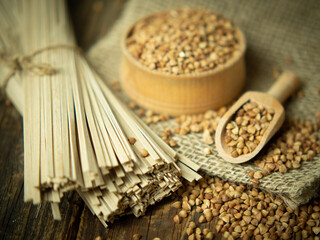 buckwheat noodles and buckwheat groats on a wooden background, rustic composition with buckwheat