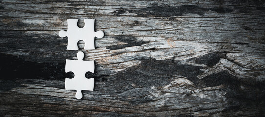 White details of jigsaw puzzle piece on wooden background. Concept of working together as a...