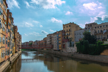 Obraz premium Colorful yellow and orange houses and famous house Casa Maso reflected in water river Onyar, in Girona, Catalonia, Spain.