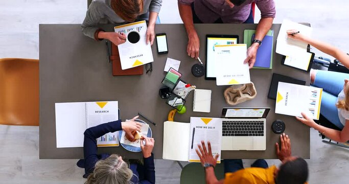 Top view, fast motion and team brainstorming, writing and planning in office. Teamwork, group project and notes for marketing strategy, sales growth and conversation with devices and online research.