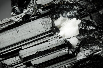 Schorl black tourmaline macro detail texture background. close-up raw rough unpolished semi-precious gemstone