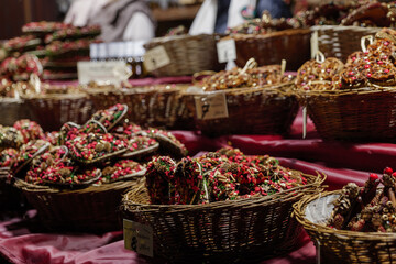 Selective focus at heap of ornamental Christmas decoration in wicker basket for sale in front of stall during winter season. 