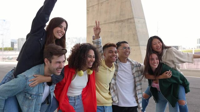 Young multi-ethnic friends having fun together posing for a group portrait outdoors. Millennial diverse people enjoying vacation together taking a photo together. Friendship concept